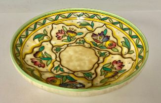 Ceramics - a Charlotte Rhead three footed bowl, tube lined with purple and pink flowers on a blue