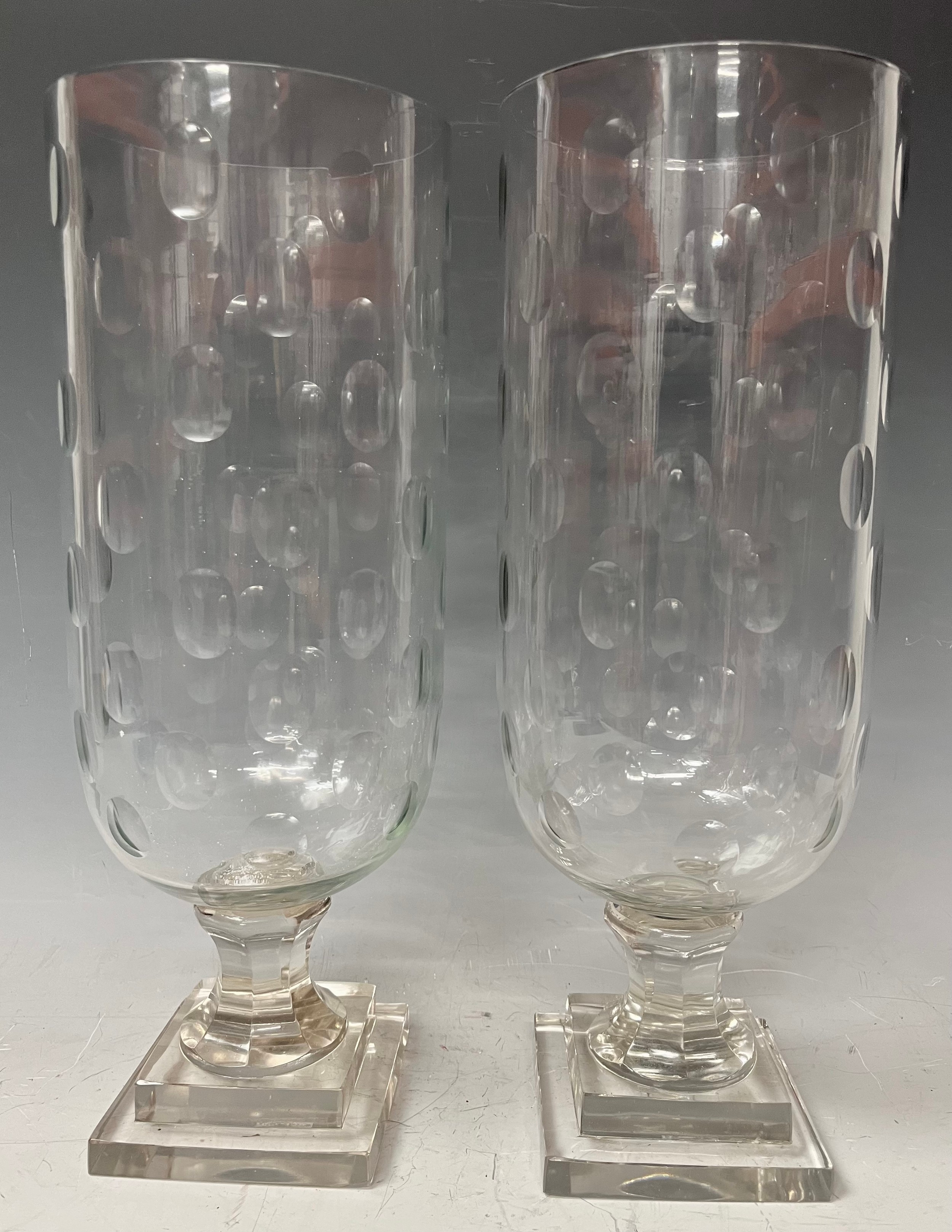 A large pair of reproduction Victorian style glass storm lamps, stepped bases, approx. 40cm high