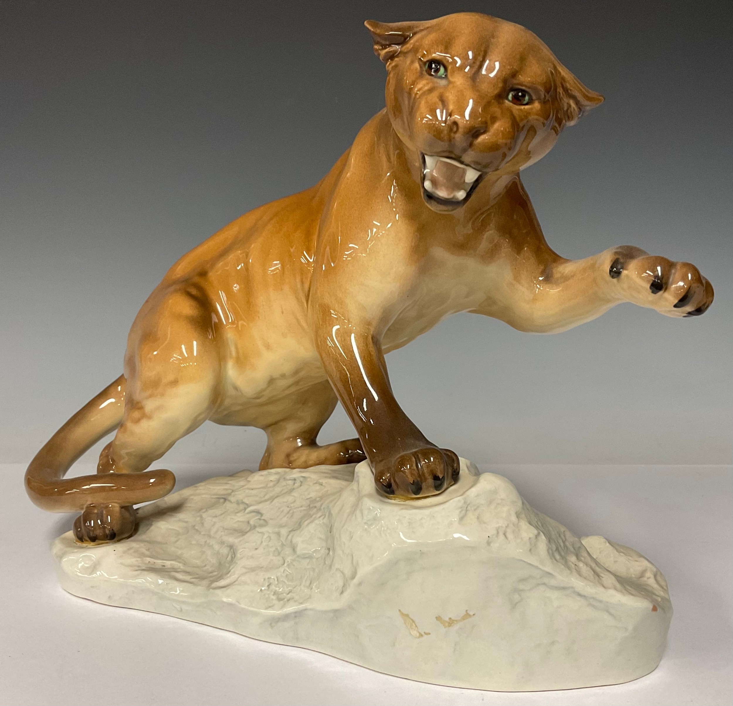 A Beswick model of a puma on a rocky outcrop, number 1702, 29cm wide, printed and impressed marks