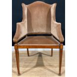 An Edwardian satinwood banded mahogany wing chair, stuffed-over upholstery, tapered square forelegs,