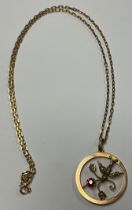 An Edwardian 9ct rose gold openwork circular pendant, as a swallow with flower in its beak, set with