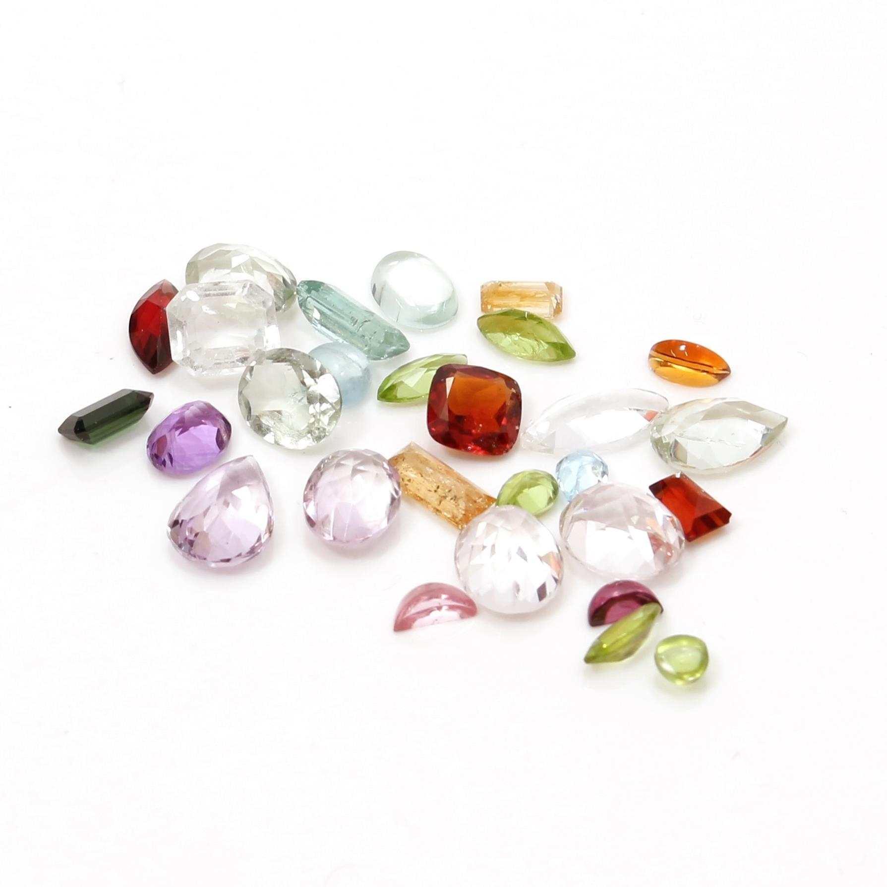 A collection of various semi-precious and glass multi-faceted gemstones and faux gemstones,