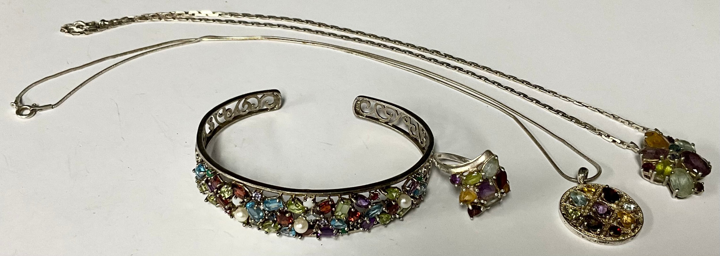 A sterling silver cuff bracelet, set with an assortment of colourful semi-precious stones, marked