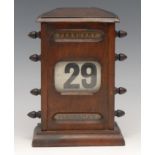 A large early 20th century perpetual desk calendar, sarcophagus cresting above glazed apertures