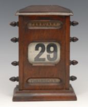 A large early 20th century perpetual desk calendar, sarcophagus cresting above glazed apertures
