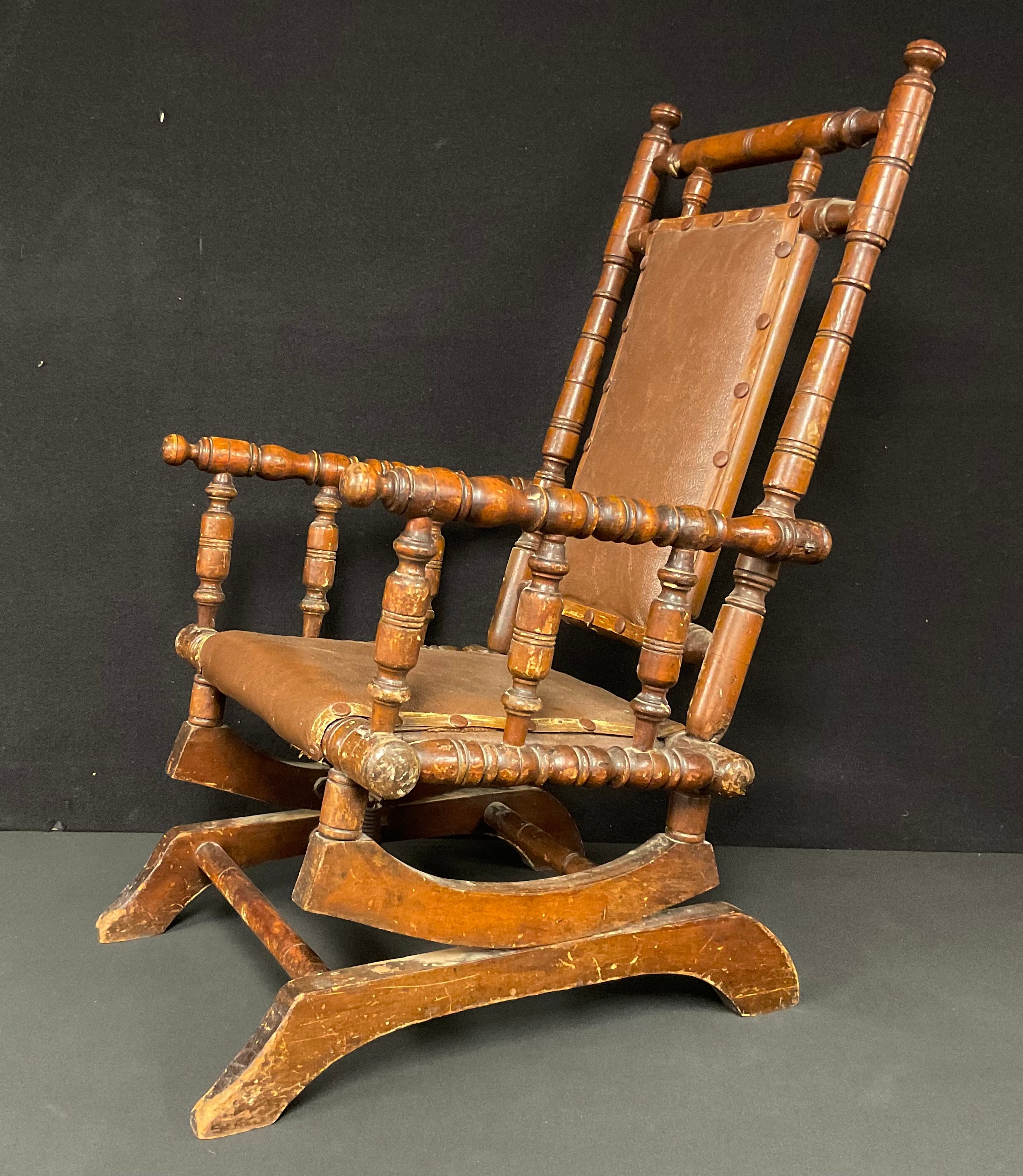 A 19th century American children’s sprung rocking chair, turned throughout, faux leather seat