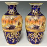 A pair of Noritake baluster vases, printed and painted with desert scenes and tall palm trees, 26cm,