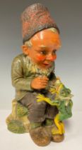 A German Heissner garden gnome model, seated with frog companion, painted in bright colours, 34cm,