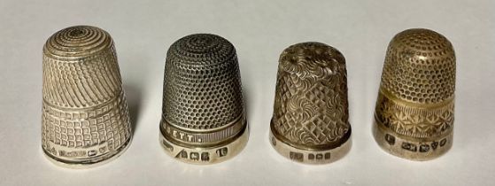 A hallmarked silver Charles Horner thimble; Good Wishes from East Barnett thimble; two other