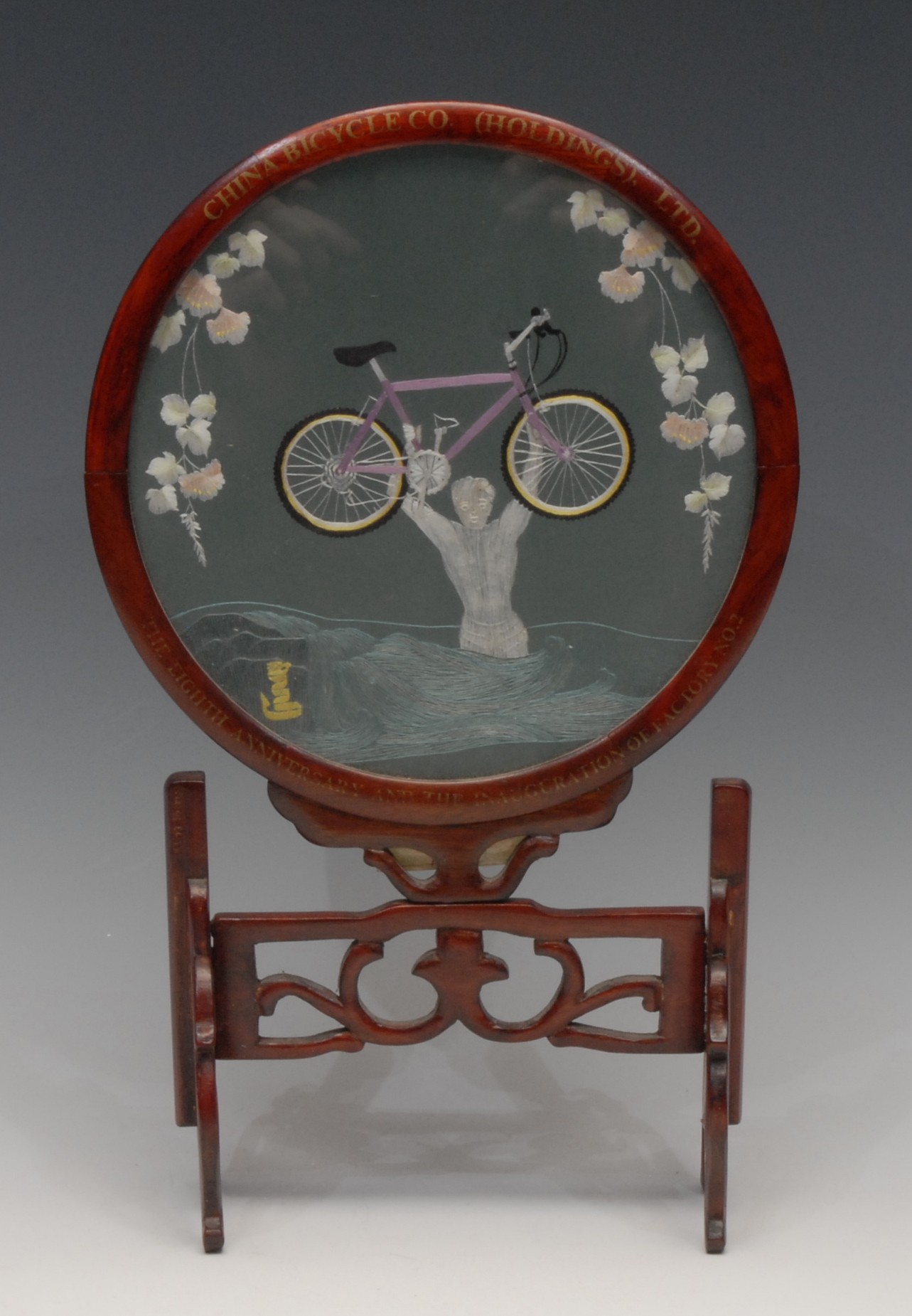 A Chinese hardwood table screen, the circular banner worked in coloured silks with a boy carrying - Image 2 of 2