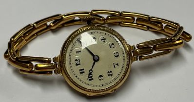 A lady's 18ct gold watch, cream enamel dial with Arabic numerals, the case interior marked 18 and .