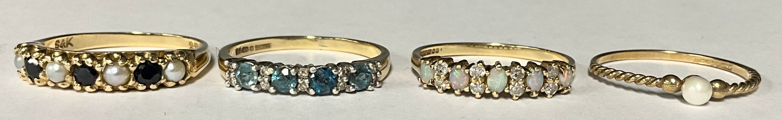 A 9ct gold sapphire and seed pearl ring, size P, marked 375, 2.3g; three other 9ct gold rings, set