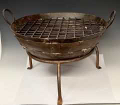 A round cast iron fire pit, tripod support, the pit 61cm wide, 48.5cm high over handles