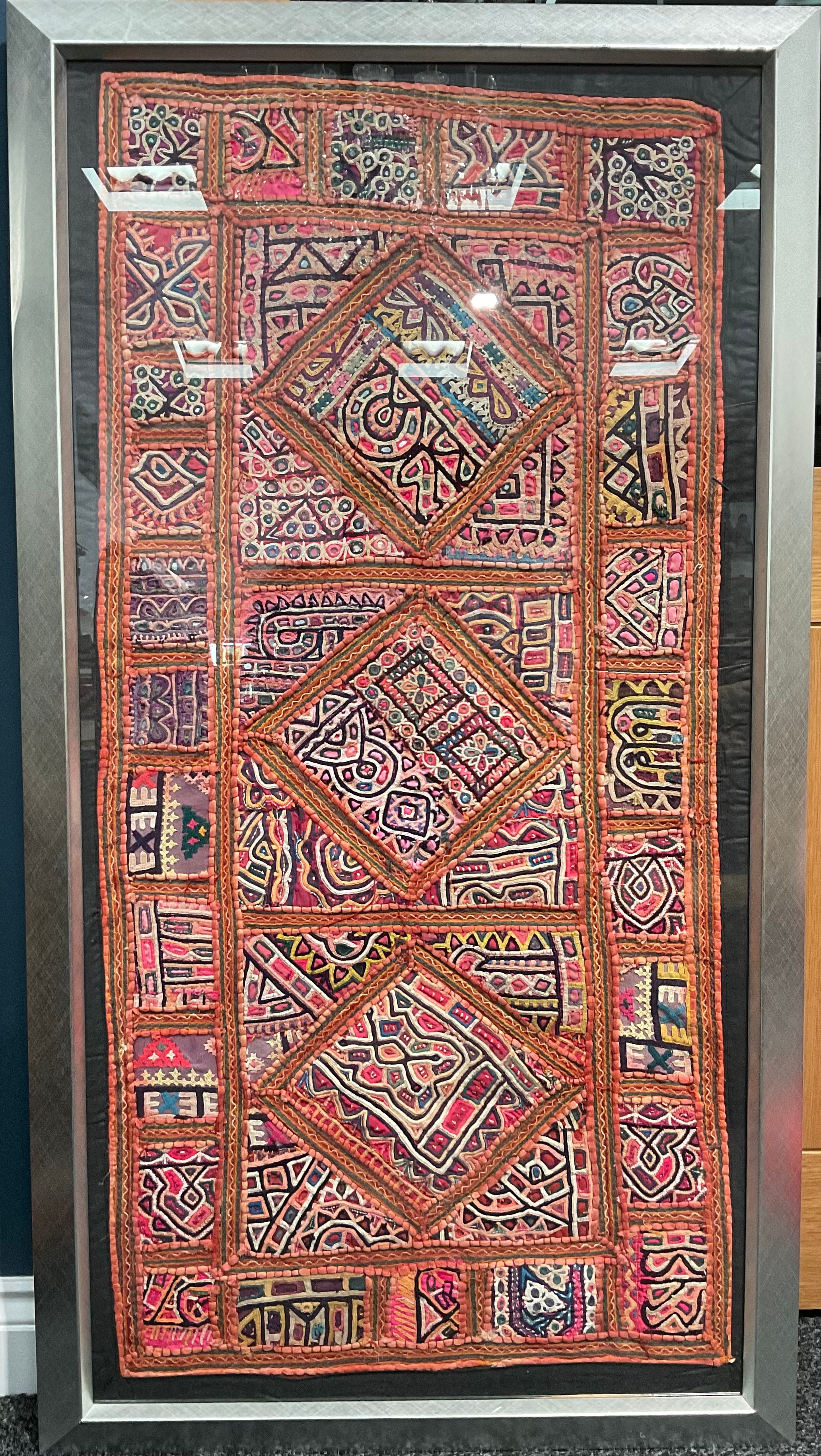 An Indian hand made woollen and cotton mat/wall hanging, some small mirrored glass inclusions, early