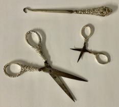 A pair of silver hafted scissors, Birmingham, 1928, 13.6g gross, 7.5cm long; another pair, unmarked,