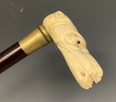 A contemporary carved bone handled walking stick, the handle as the head of a dog, 84cm long