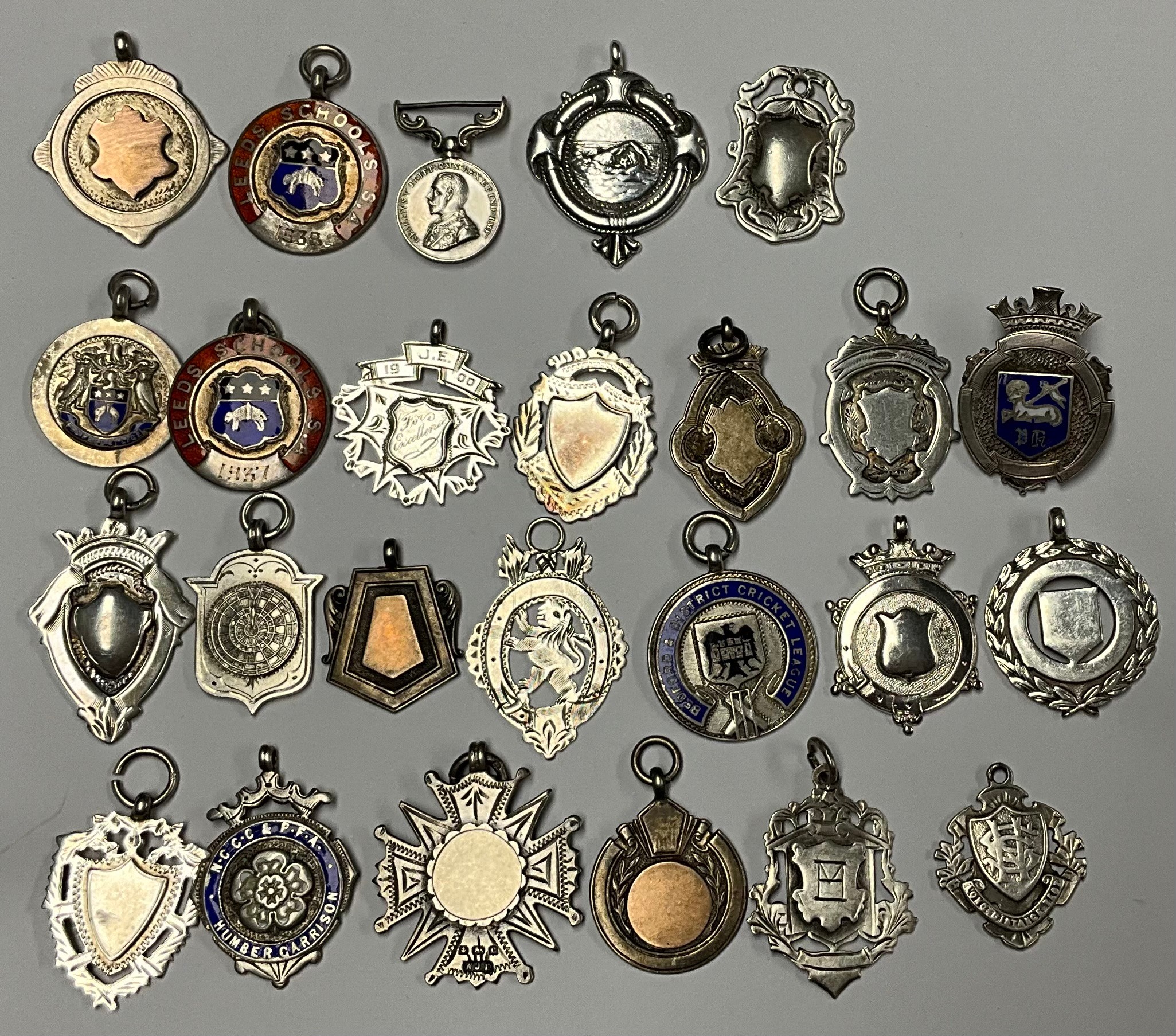 An Edwardian silver swimming award fob, Birmingham 1909, assorted other silver and enameled fobs,
