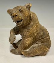 A German Black Forest carved wooden bear, seated, glass eyes, 11.5cm, c.1900