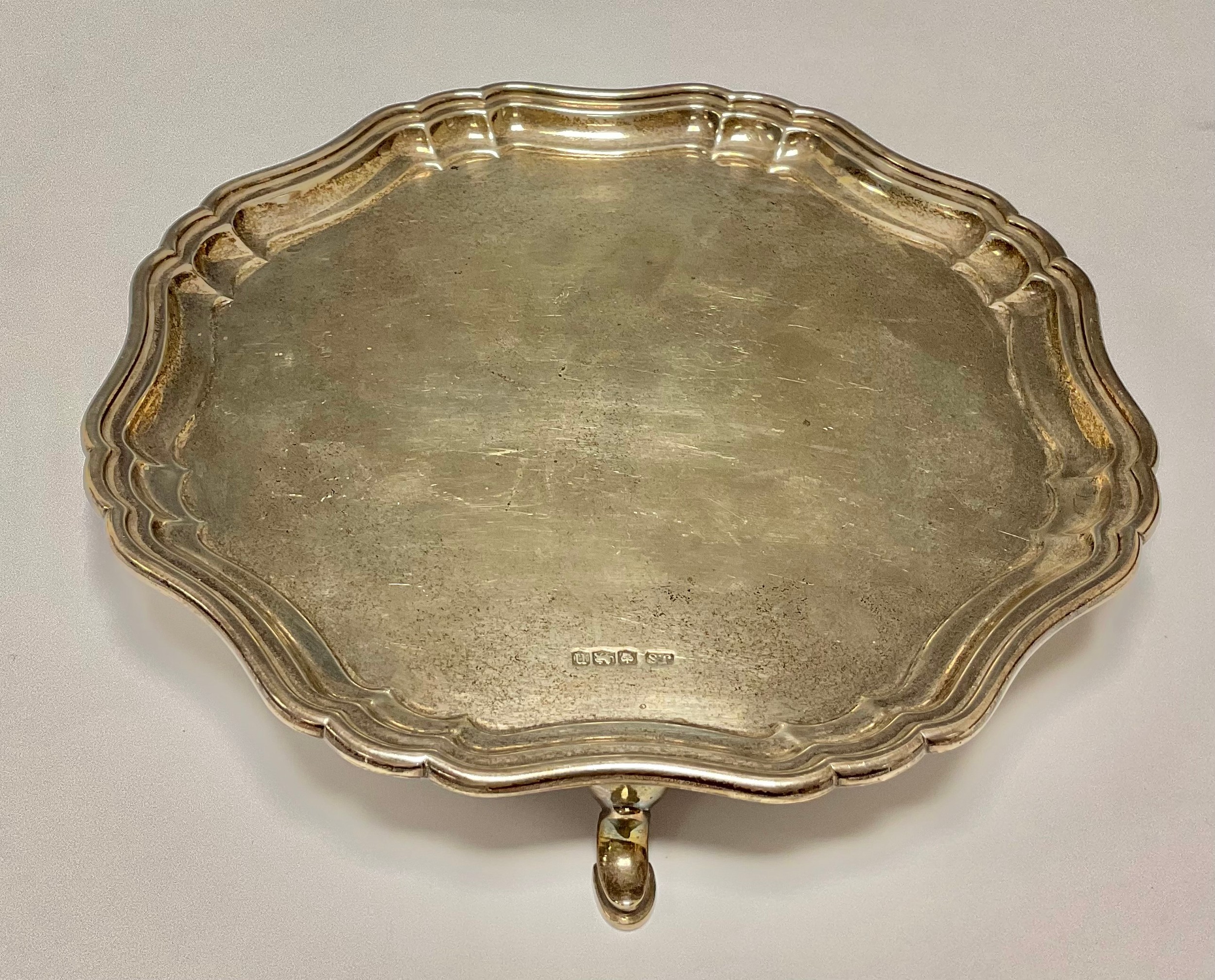 A George III style silver card tray, pie crust border, pad feet, 20cm diameter, Sheffield, 1930,