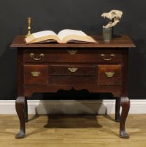 An 18th century oak lowboy, rectangular top with reentrant foreangles above four drawers, shaped