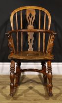 A 19th century ash and elm child’s Windsor rocking chair, pierced splat, yew crinoline stretcher,