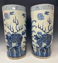 A pair of contemporary blue and white glazed circular floor standing sleeve vases, decorated in