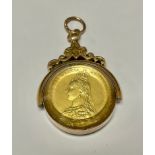 A 9ct gold mounted swivel fob, set with a gilt and enamelled Victorian shilling