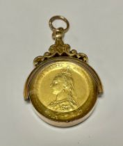 A 9ct gold mounted swivel fob, set with a gilt and enamelled Victorian shilling