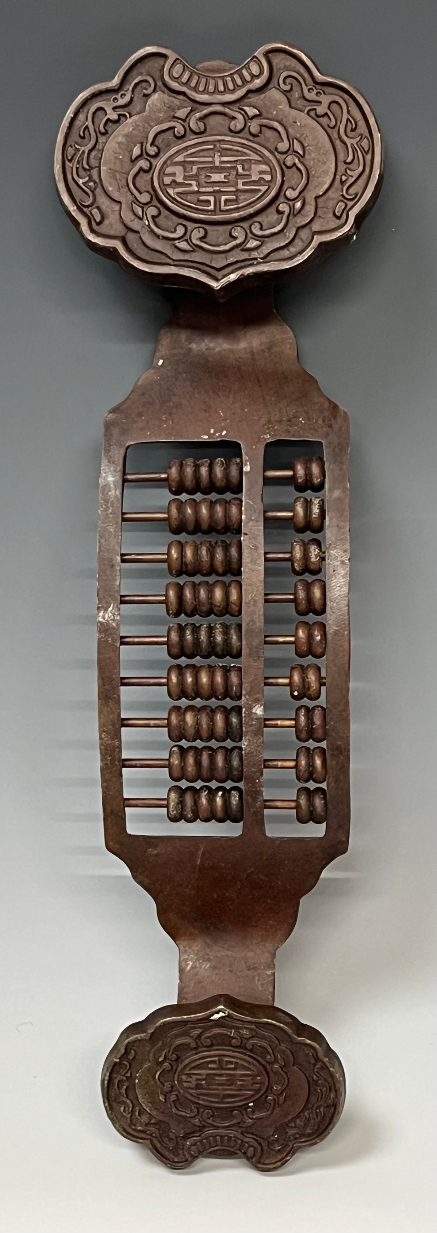 A Chinese Archaic style bronzed metal ruyi sceptre, set with abacus type beads, 32cm long