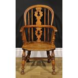 A 19th century ash and elm child’s Windsor elbow chair, pierced ‘Christmas tree’ splat, 67cm high,