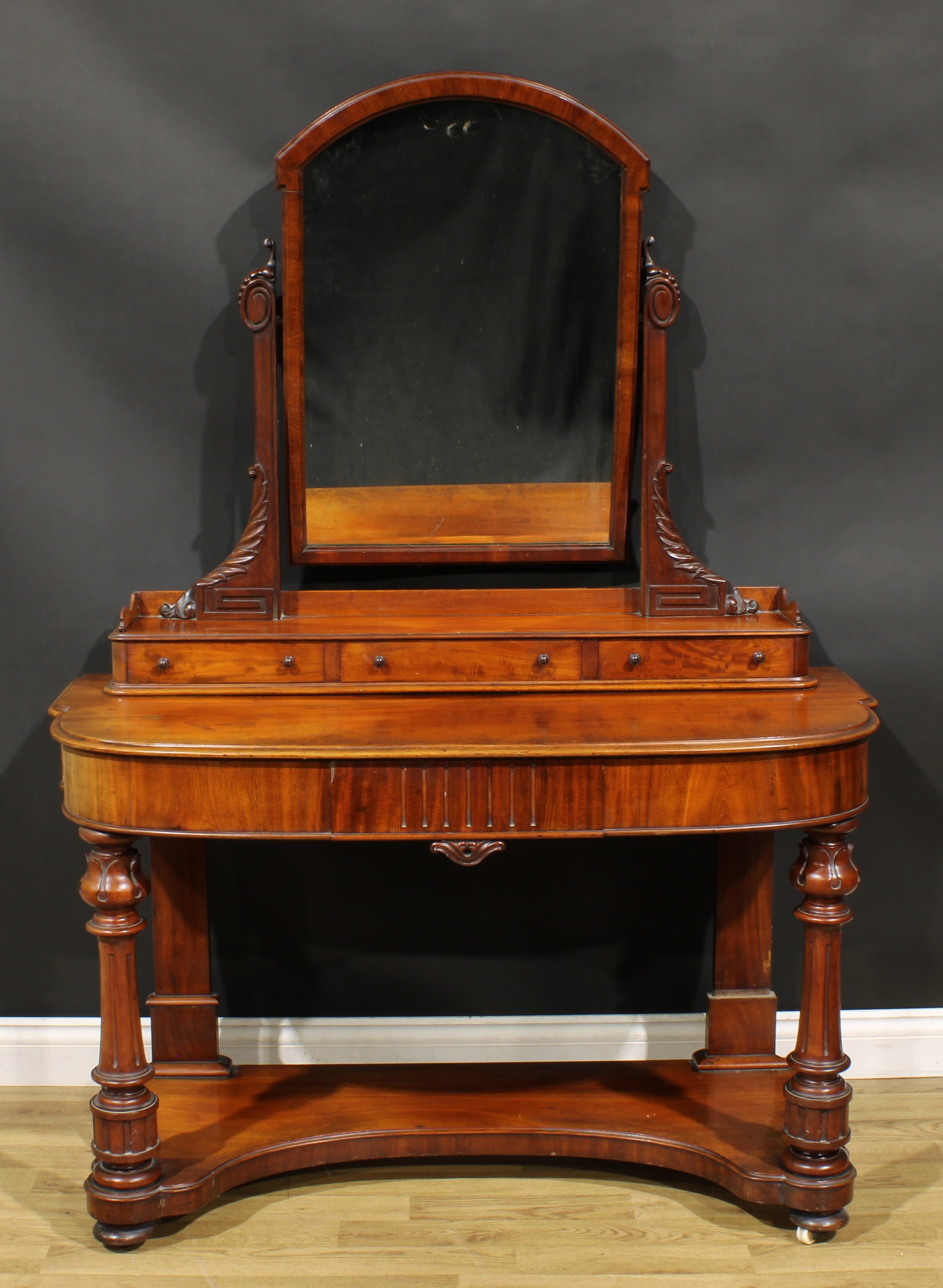 A Victorian mahogany duchess dressing table, arched rectangular mirror above three small drawers,