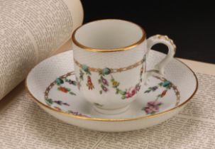 A Bristol coffee cup and saucer, basket weave moulded border, enamelled with polychrome swags