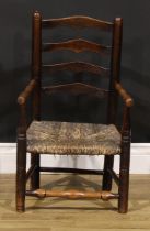 A 19th century elm child's chair, shaped ladder back, turned arms, legs and stretchers, rush seat,
