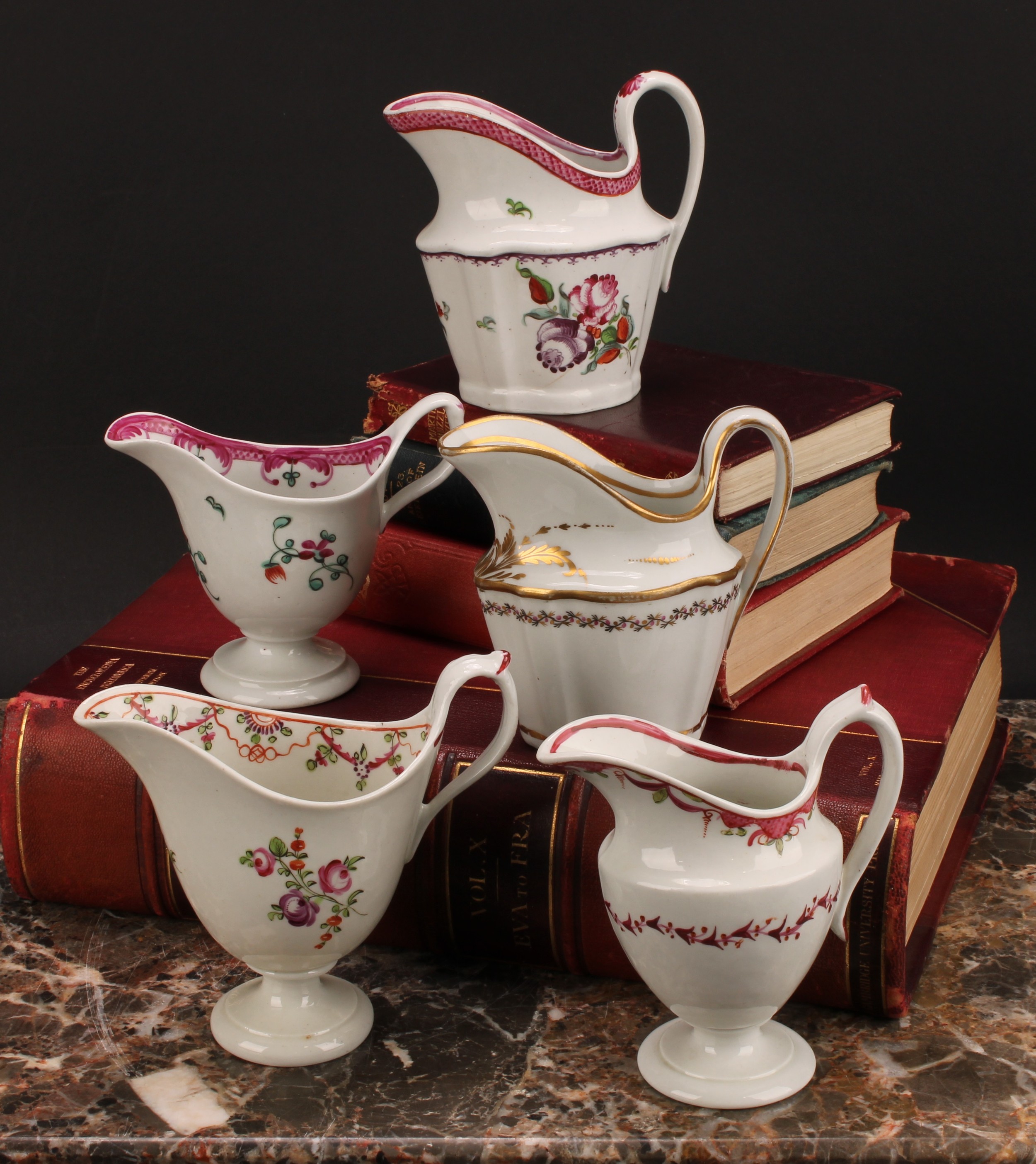 A Newhall helmet shaped cream jug, painted with scattered flowers, the interior with stylised floral