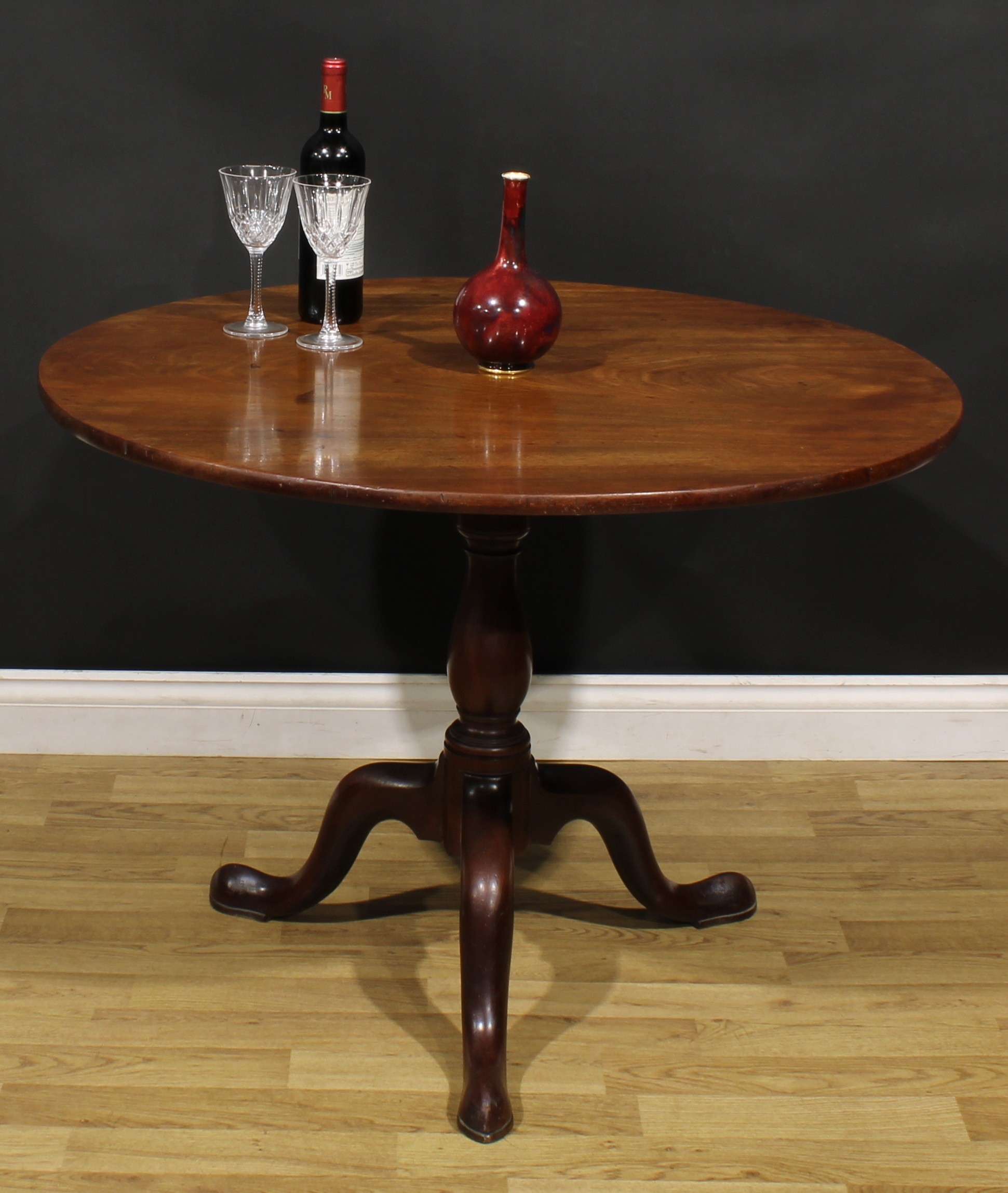 A George III mahogany birdcage tripod supper table, one-piece circular tilting top, baluster column,