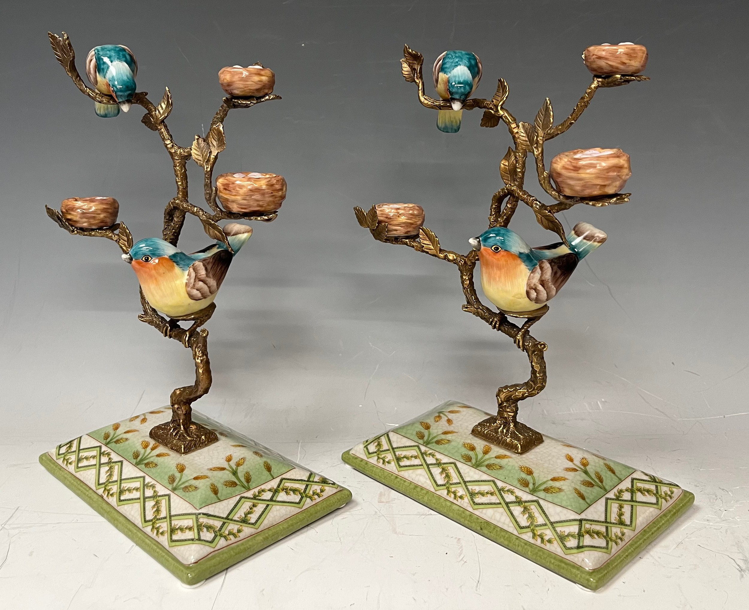 A pair of gilt metal tree stands with hand painted porcelain birds perched on the tree, faux mark,