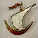 A Scandinavian silver gilt enamel brooch as a ship at full sail, in red and white, marked 925