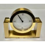 A Tiffany & Co brass clock, white circular dial with Roman numerals to quarters, rotating on a