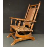 A 19th century American children’s sprung rocking chair, turned throughout, faux leather seat