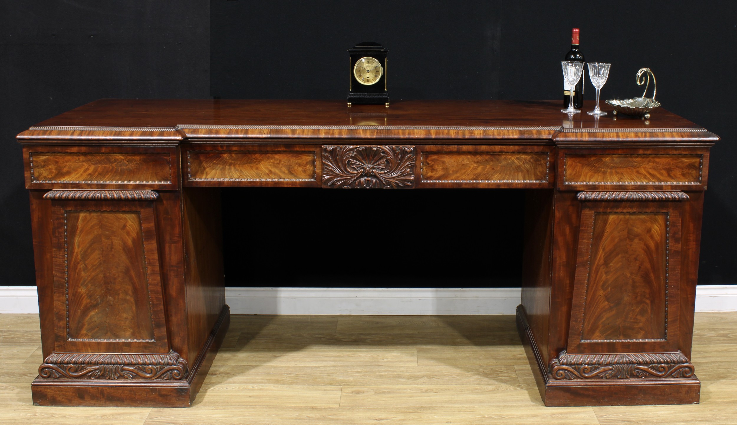A William IV mahogany sideboard, inverted break-centre top above a pair of frieze drawers, carved to