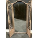 Interior Decoration - a large arched top rectangular wall mirror set behind a pair of metal garden