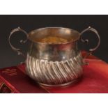 A George III silver wrythen-fluted porringer, of 17th century design, 18cm over handles, London,