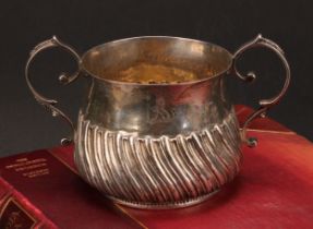 A George III silver wrythen-fluted porringer, of 17th century design, 18cm over handles, London,