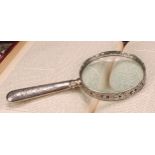 A Victorian silver magnifying glass, the bezel pierced and cast with flowering foliate scrolls,