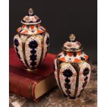 An associated pair of Royal Crown Derby ovoid vases, pierced domed covers and finials, 21cm high,