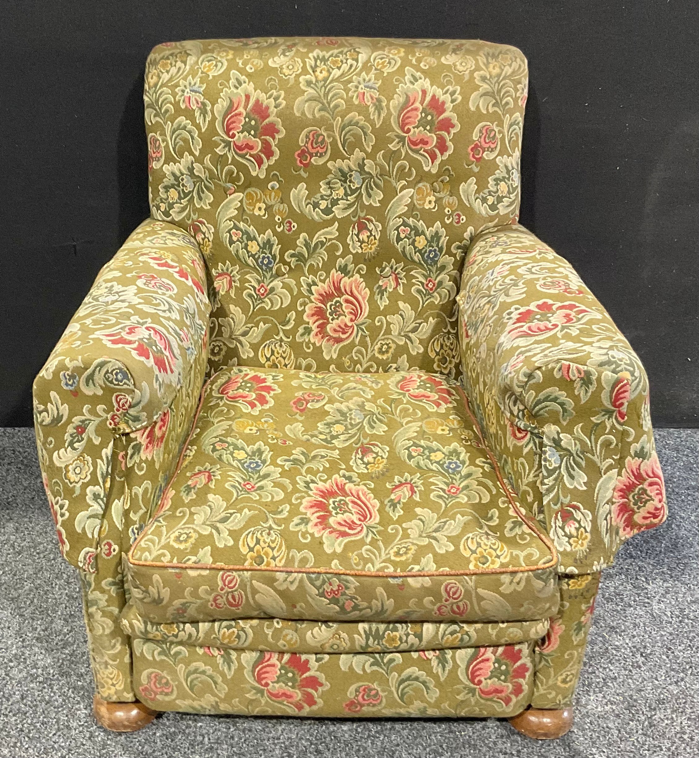 An early 20th century country house easy chair, stuffed-over upholstery, squab cushion, turned