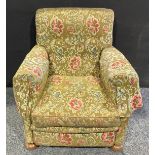 An early 20th century country house easy chair, stuffed-over upholstery, squab cushion, turned