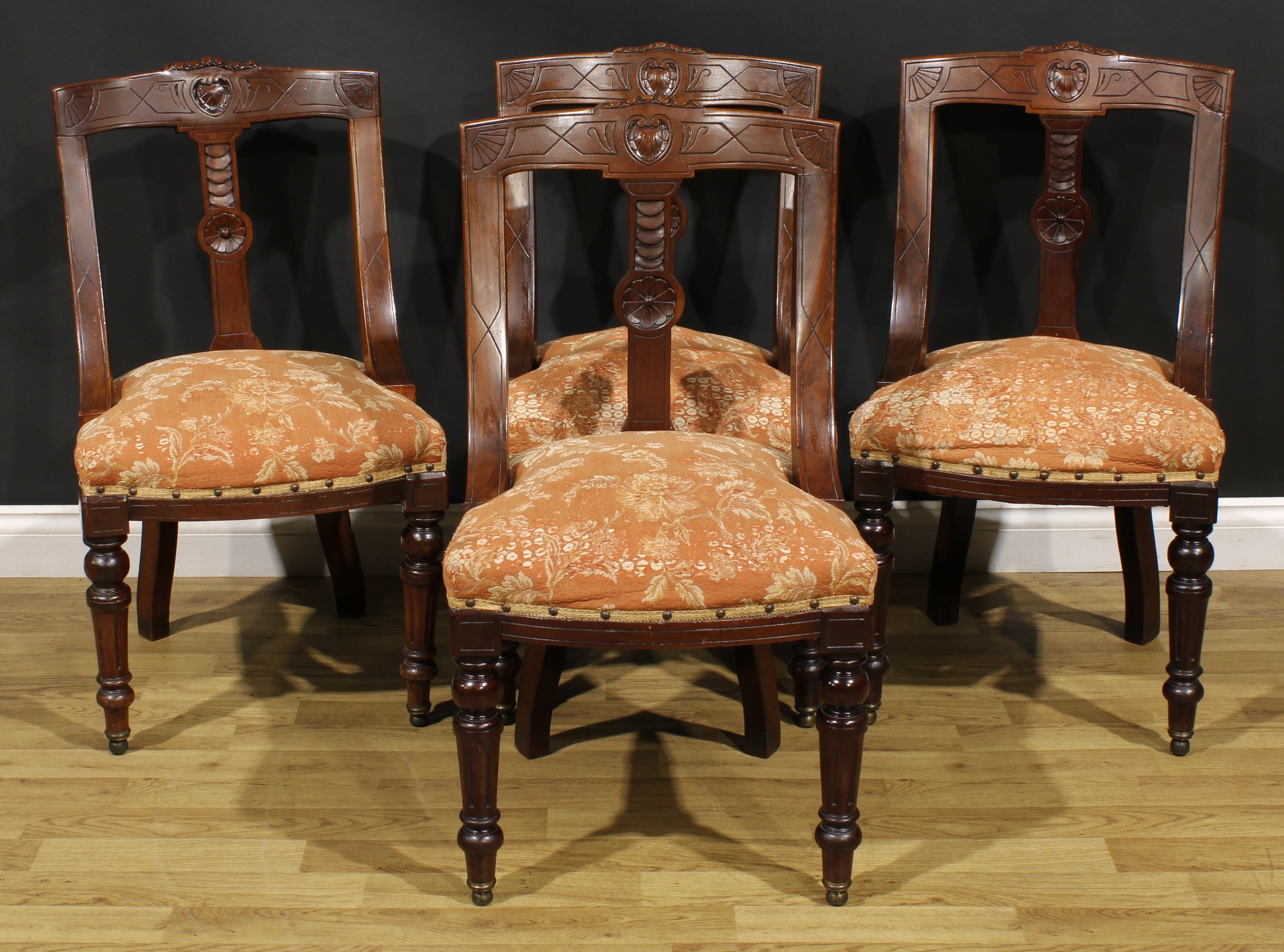 A set of four late Victorian walnut gondola form dining chairs, each curved cresting rail carved