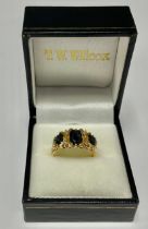 An 18ct gold sapphire three stone ring, the stones interspersed with four diamond chips, size O,