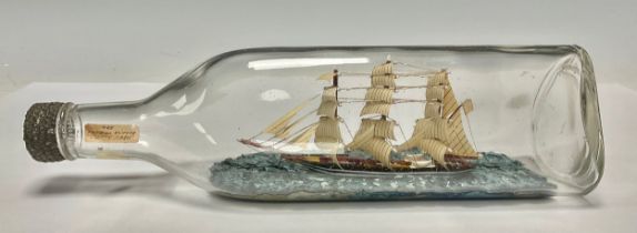 A 20th century model ship in a bottle, labelled ‘The Famous Clipper The “Cutty Sark”,’ 29cm long
